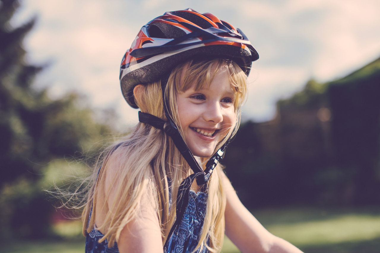 Lächelndes Mädchen mit einem Fahrradhelm